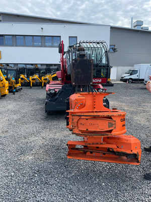 Orangefarbenes Wurzelfräsaggregat auf dem Betriebshof – Gerät für das Fräsen von Baumstubben.